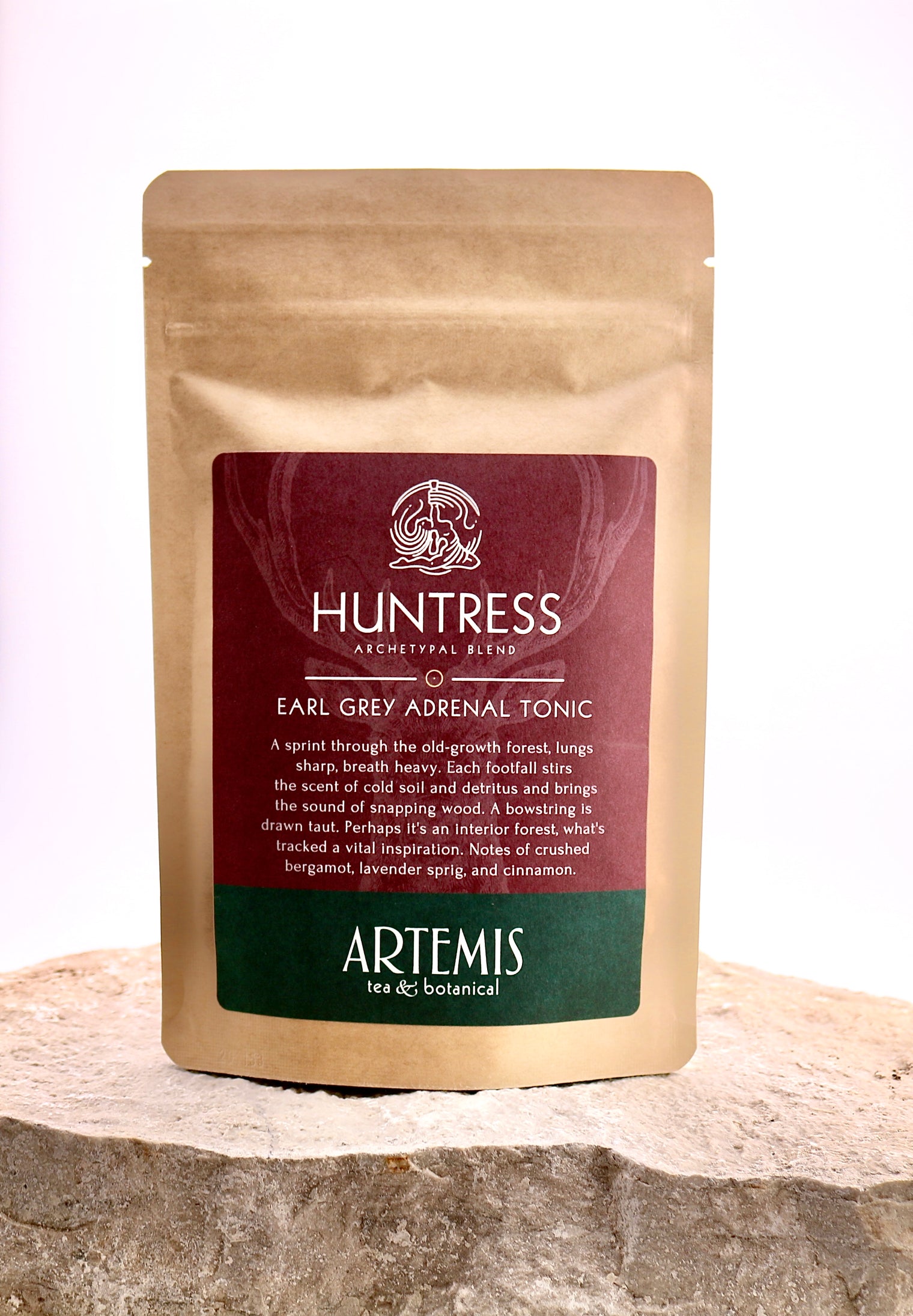 Tea package labeled 'Huntress' by Artemis on a wooden surface with a white background