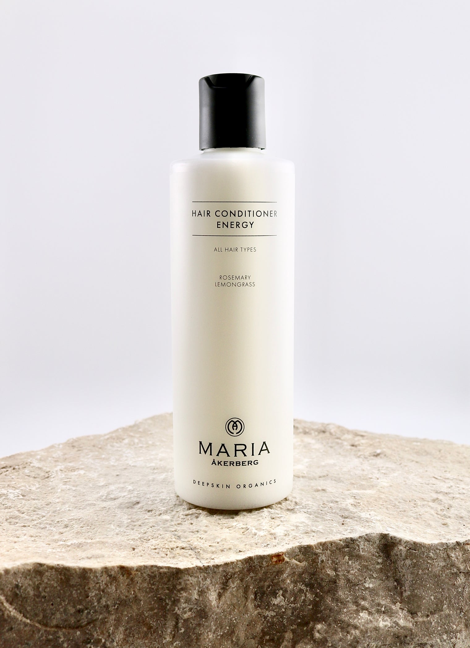 Hair conditioner bottle labeled 'Maria Åkerberg' on a stone surface with a light gray background