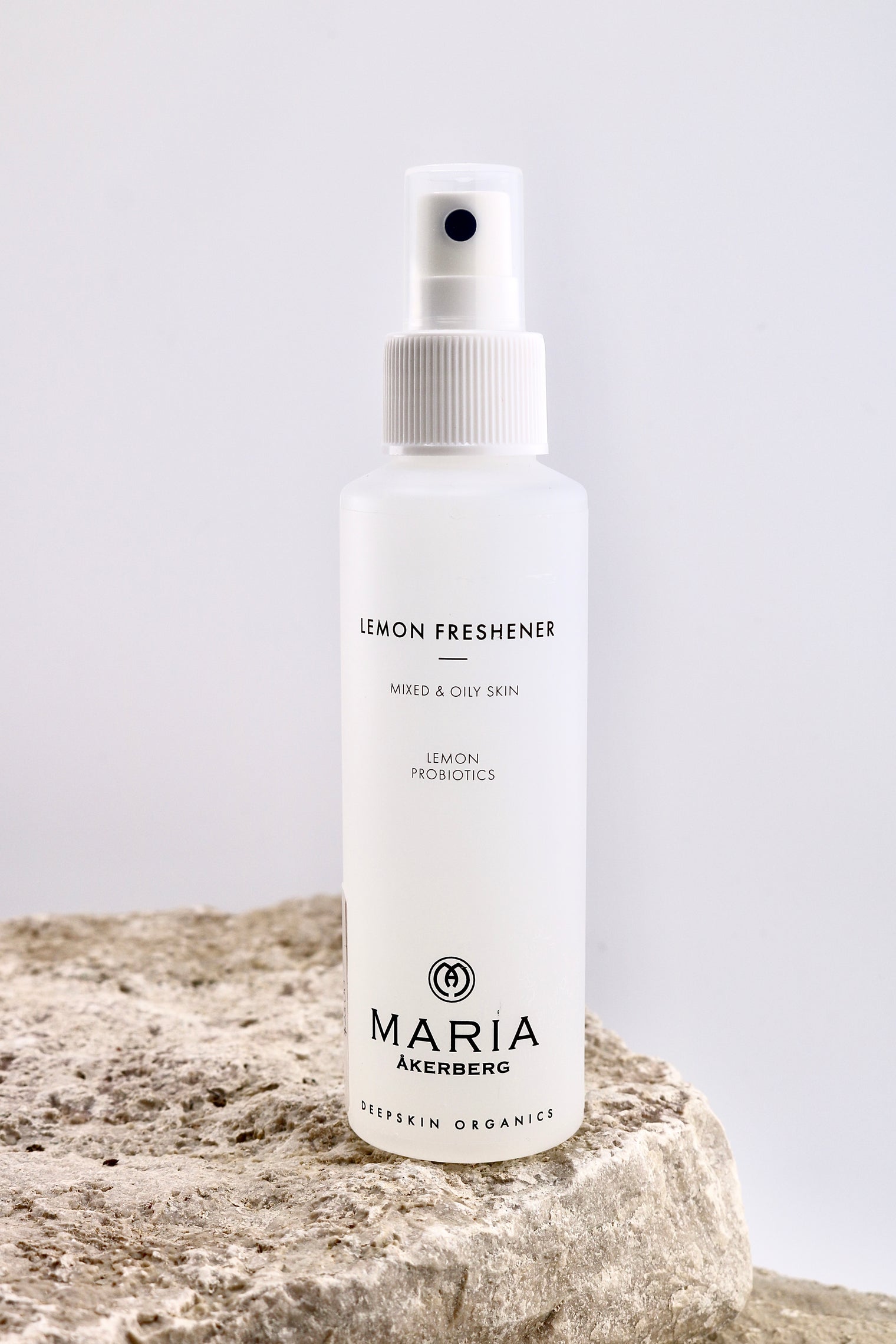 White spray bottle labeled 'Lemon Freshener' by Maria Åkerberg on a light gray background