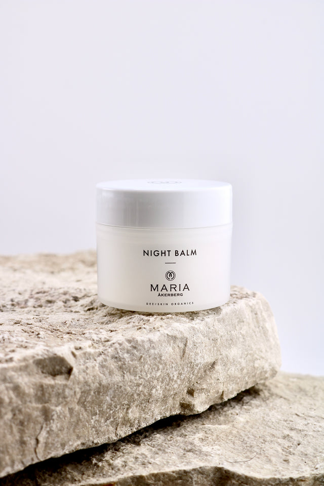 Jar of night balm labeled 'Maria' on a stone surface with a light gray background