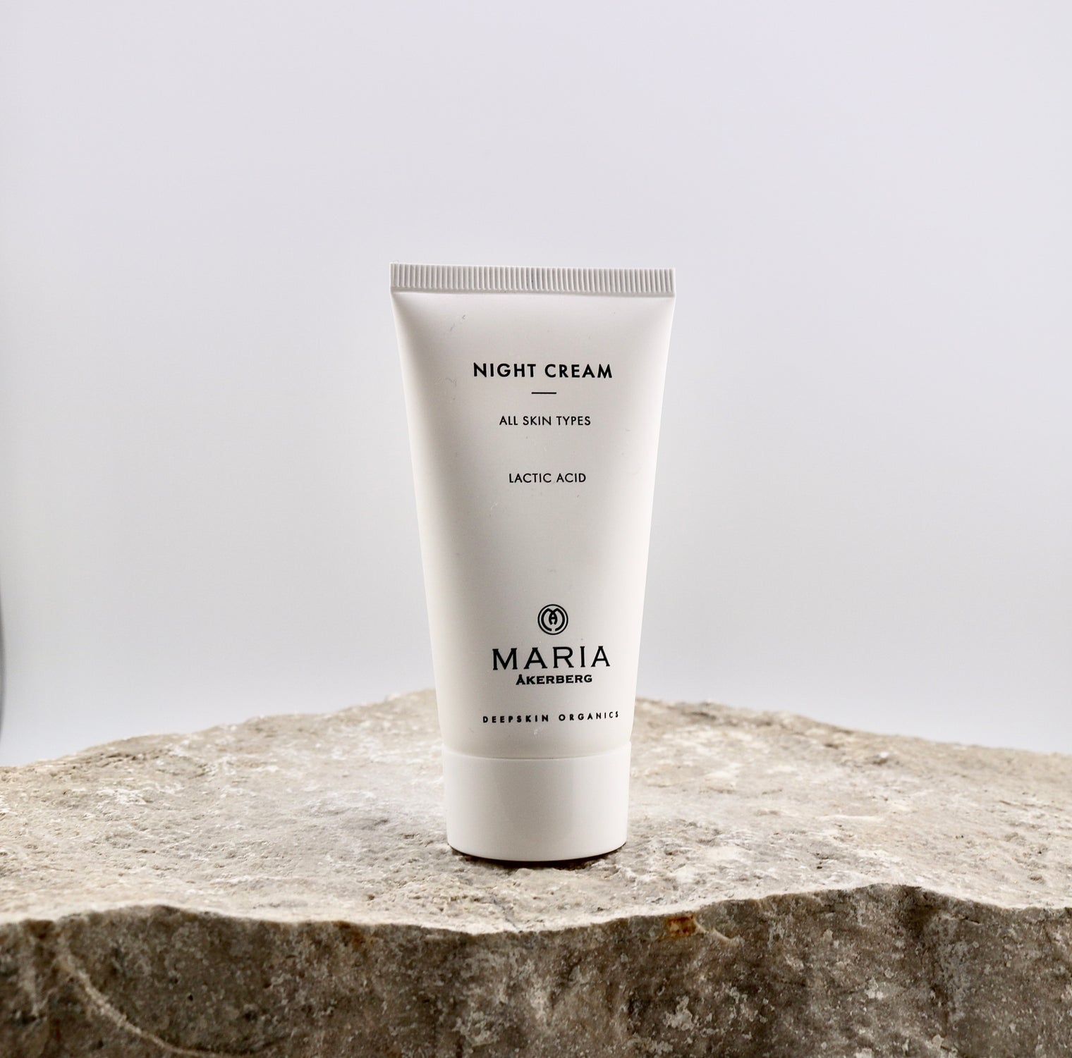 Tube of Maria Åkerberg night cream on a stone surface with a light gray background