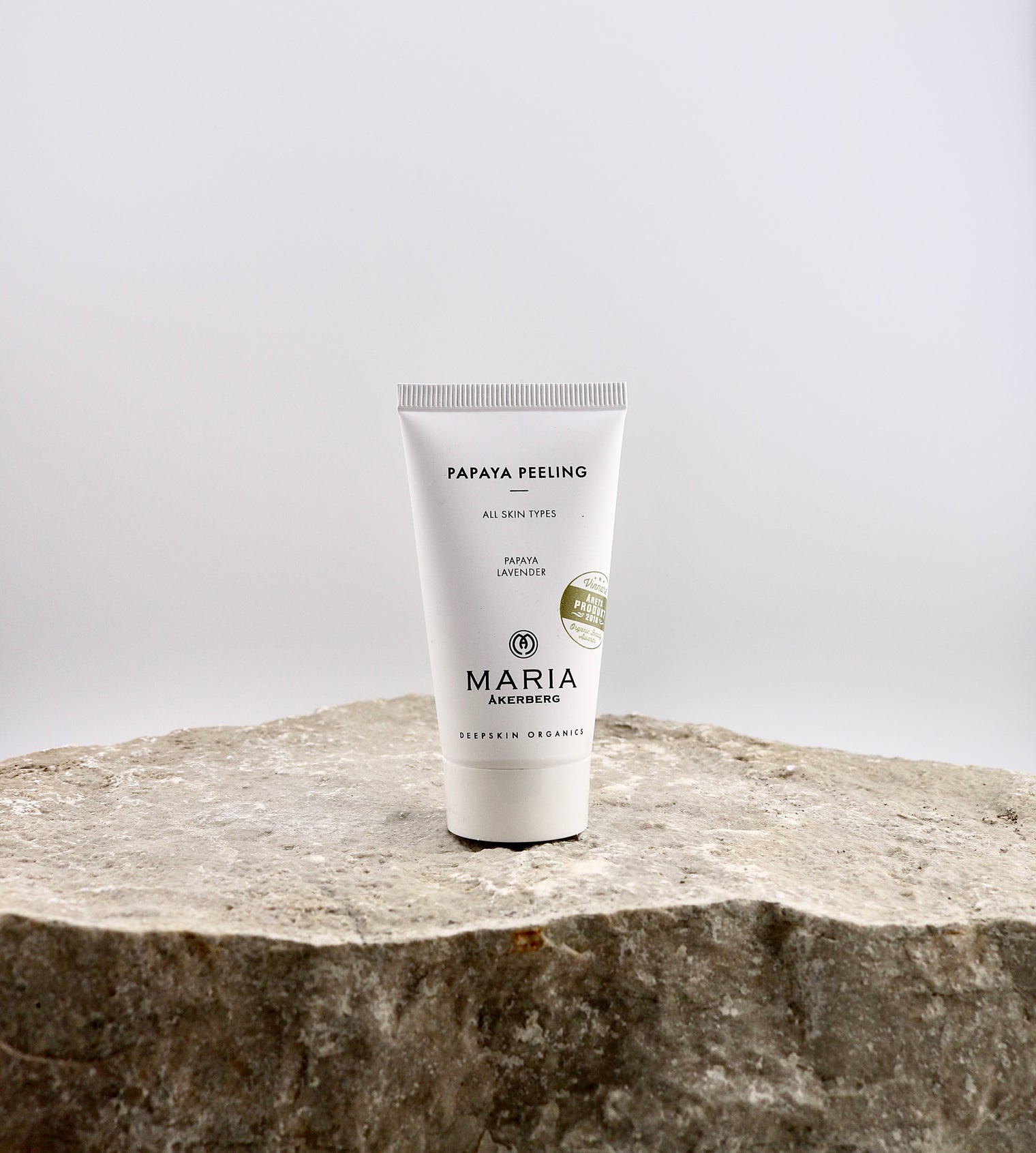 Tube of Maria Papaya Peeling on a stone surface with a light gray background