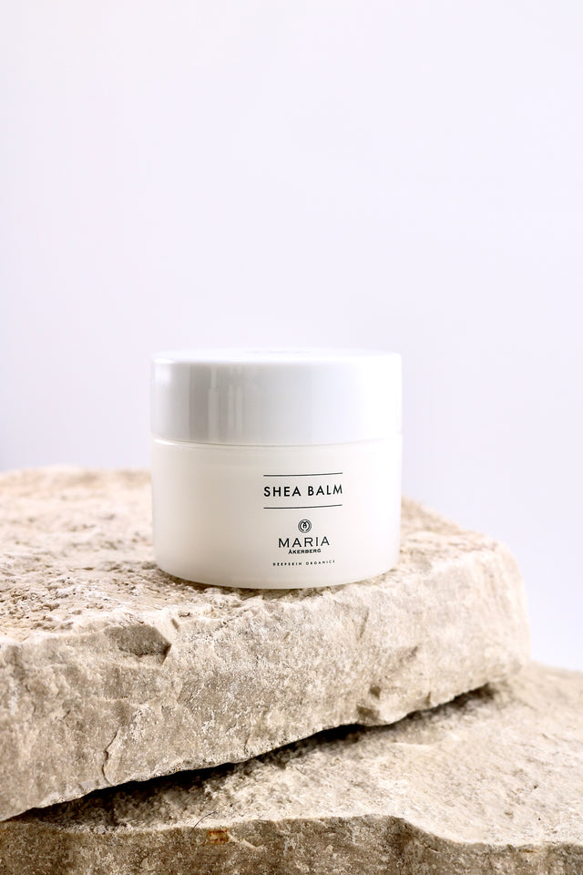Shea balm jar labeled 'Maria' on a stone surface with a light background
