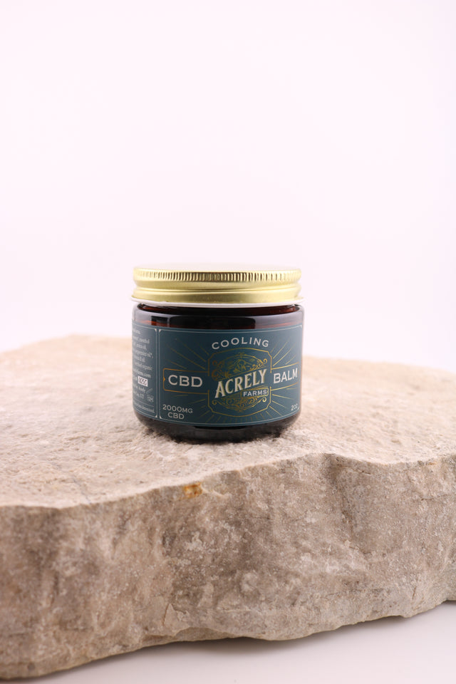 Bottle of CBD product on a stone surface with a white background