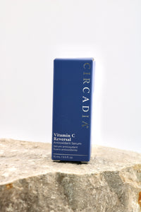 A blue rectangular box of Circadia Vitamin C Reversal Antioxidant Serum standing upright on a textured stone surface against a plain white background.