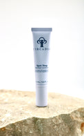 Circadian Spot Stop Cream tube on a stone surface with a white background