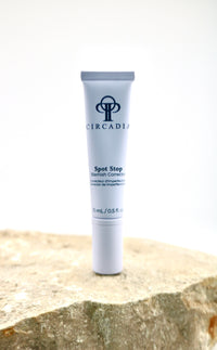 Circadian Spot Stop Cream tube on a stone surface with a white background