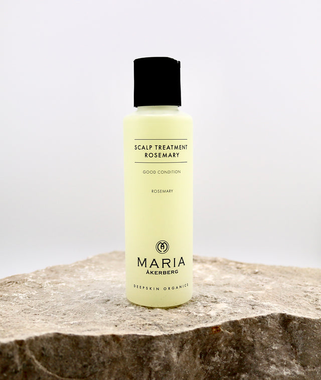 Bottle of Maria Akerberg scalp treatment with rosemary on a stone surface