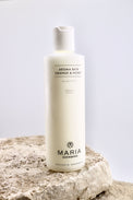 Bottle of Maria Åkerberg Aroma Bath Orange & Honey on a stone surface with a light gray background