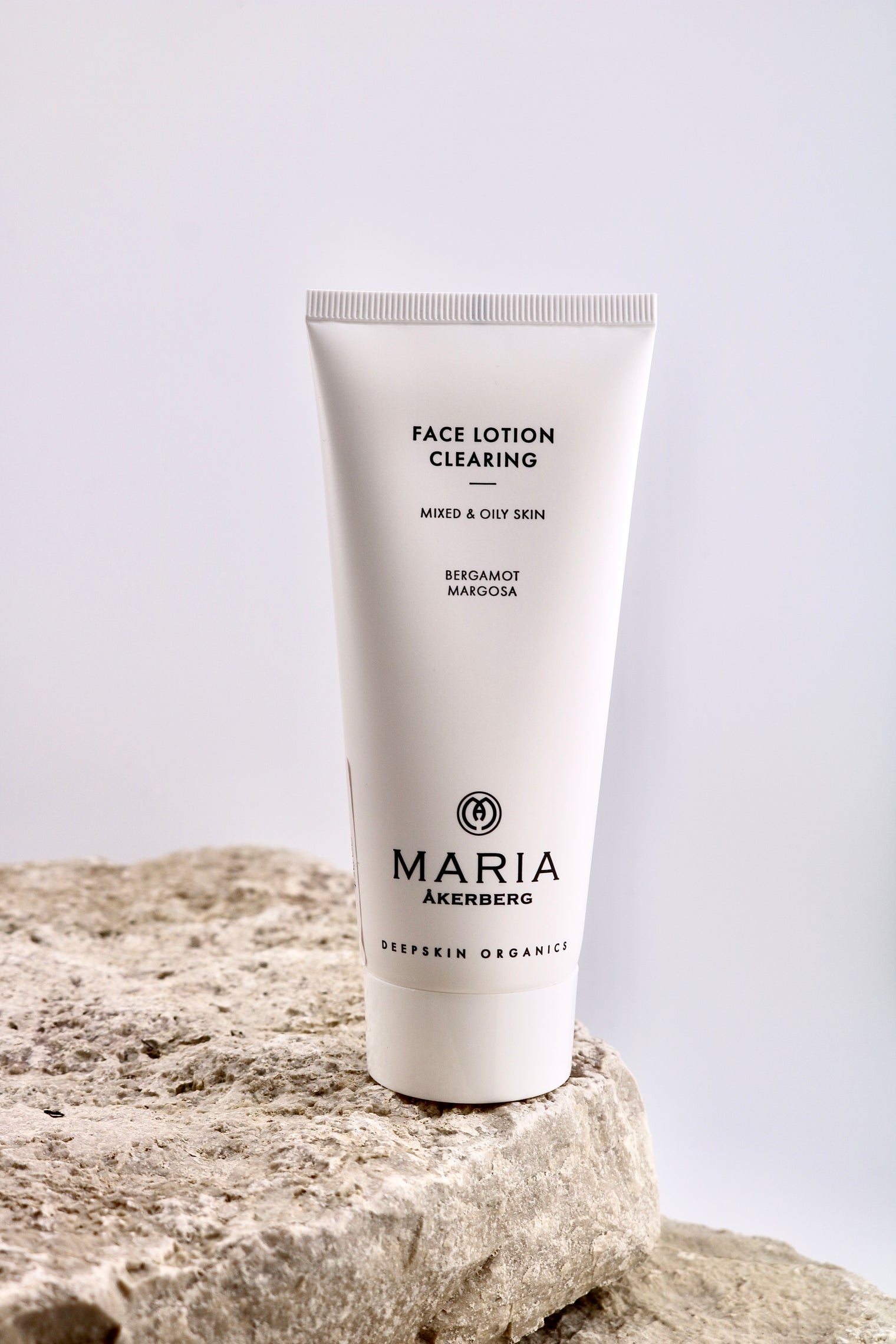 Tube of Maria Åkerberg face lotion on a rock with a light gray background