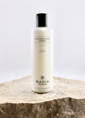 Hair conditioner bottle labeled 'Maria Åkerberg' on a stone surface with a light gray background