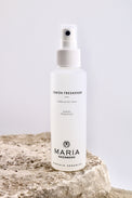 White spray bottle labeled 'Lemon Freshener' by Maria Åkerberg on a light gray background