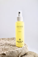 Spray bottle labeled 'Maria Åkerberg' on a stone surface with a light gray background
