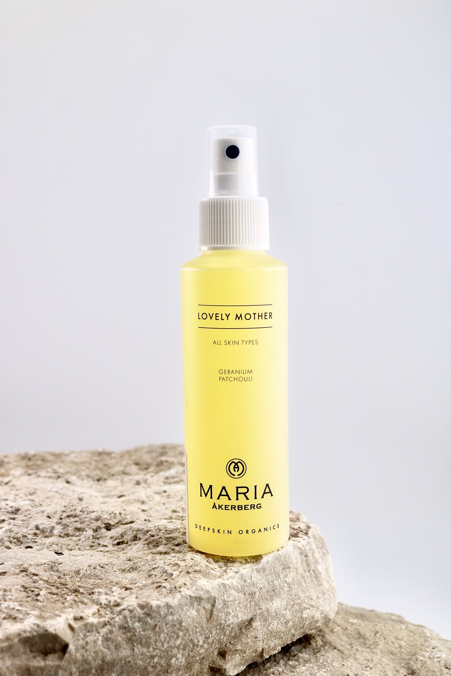 Spray bottle labeled 'Maria Åkerberg' on a stone surface with a light gray background