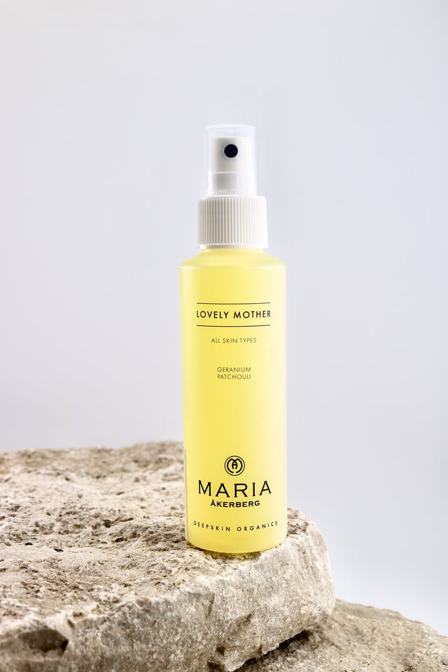 Spray bottle labeled 'Maria Åkerberg' on a stone surface with a light gray background