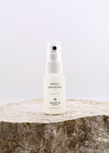 White spray bottle labeled 'Neroli Freshener' by Maria on a stone surface with a light gray background