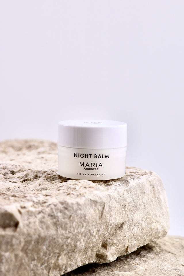 Jar of Night Balm Maria on a stone surface with a white background