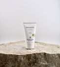 Tube of Maria Papaya Peeling on a stone surface with a light gray background