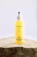 Yellow bottle of Maria Åkerberg pre-cleansing oil on a stone surface with a white background