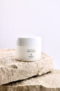 Shea balm jar labeled 'Maria' on a stone surface with a light background
