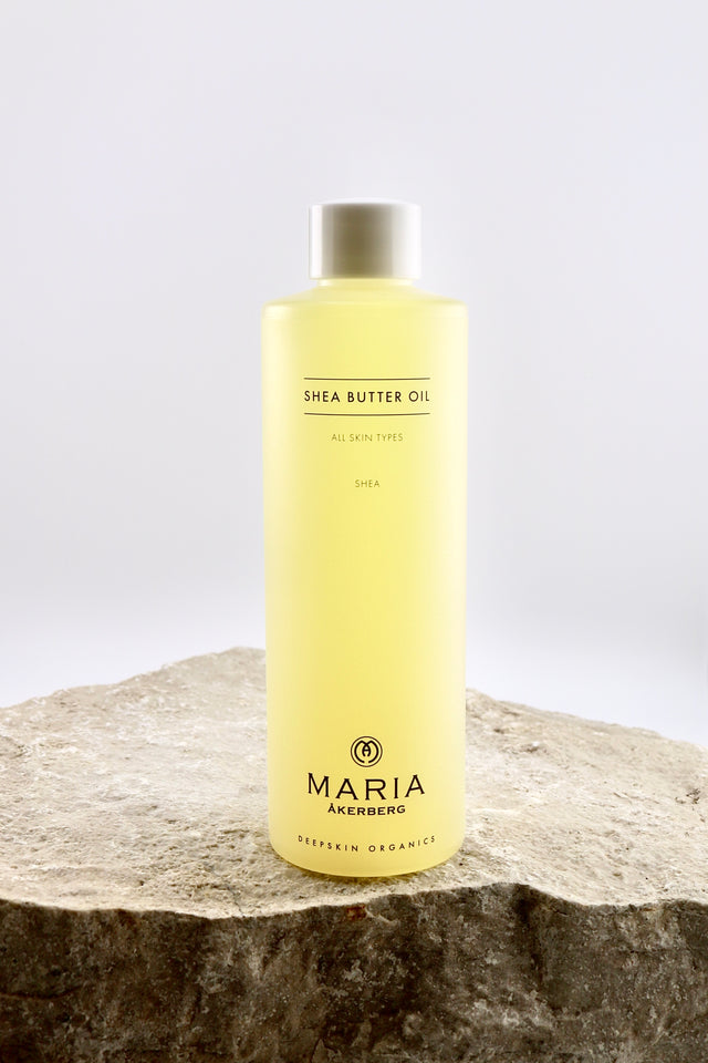 Bottle of Maria Åkerberg shea butter oil on a stone surface with a white background