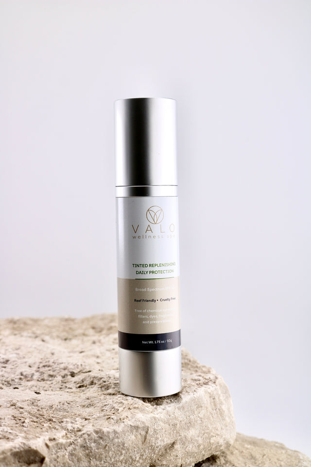 Skincare bottle on a rock with a white background